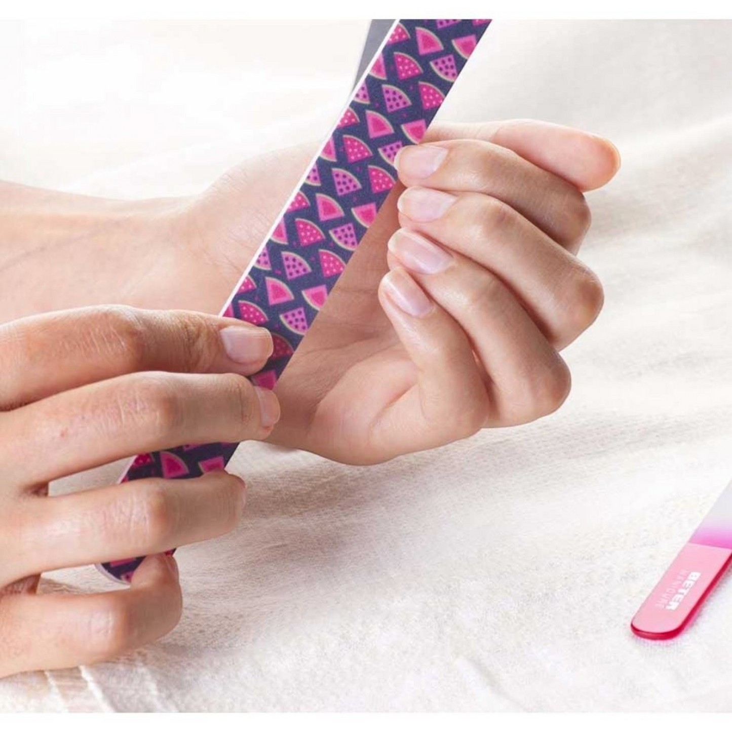 Said Salem fibreglass nail file with a pink and purple watermelon pattern being used to shape fingernails