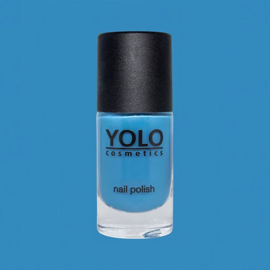 Said Salem YOLO Blue high-pigment sky blue nail polish in a glass bottle with a black cap against a blue background.