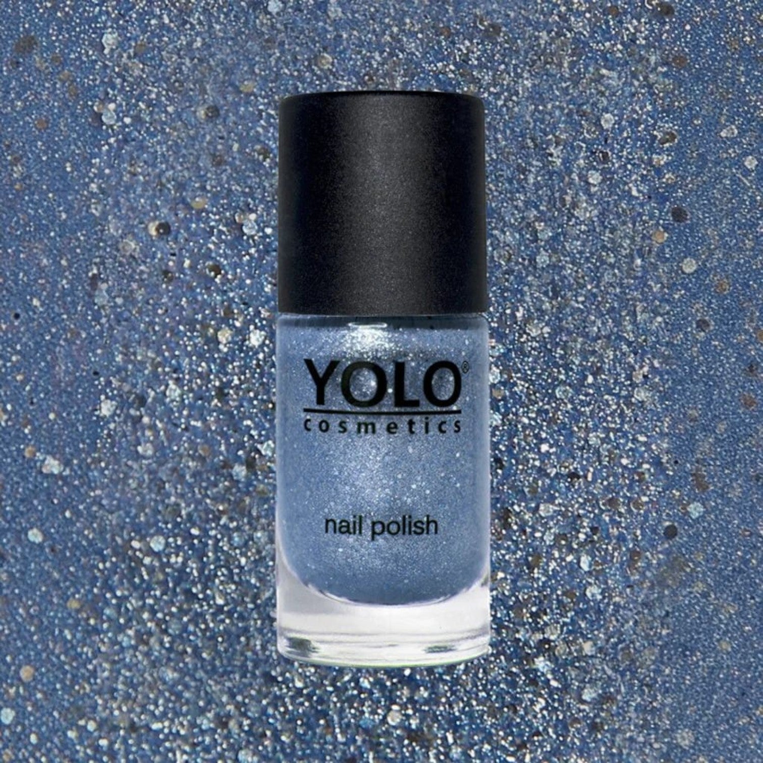 Said Salem YOLO Blue shimmer nail polish in a glass bottle with a black cap against a matching glittery blue background