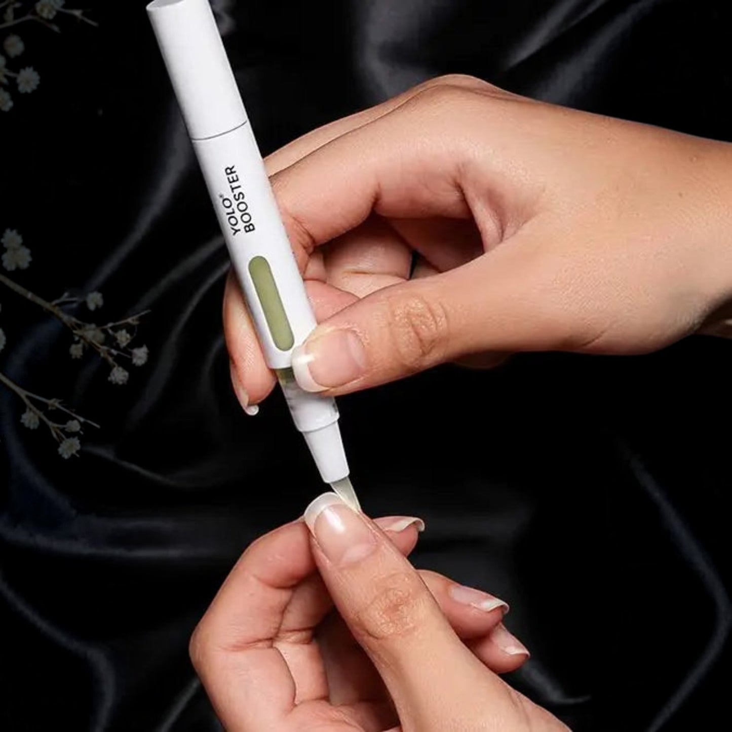 Said Salem YOLO Booster Serum Pen applying nourishing treatment to a fingernail with a precision brush tip applicator
