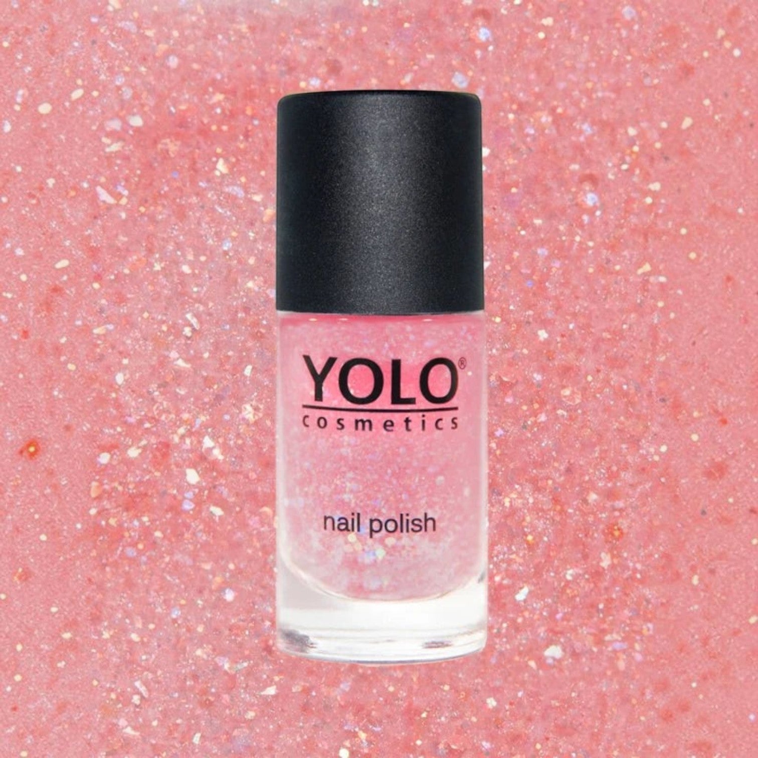 Said Salem YOLO Pink shimmering glitter nail polish in a clear glass bottle with a black cap against a pink background