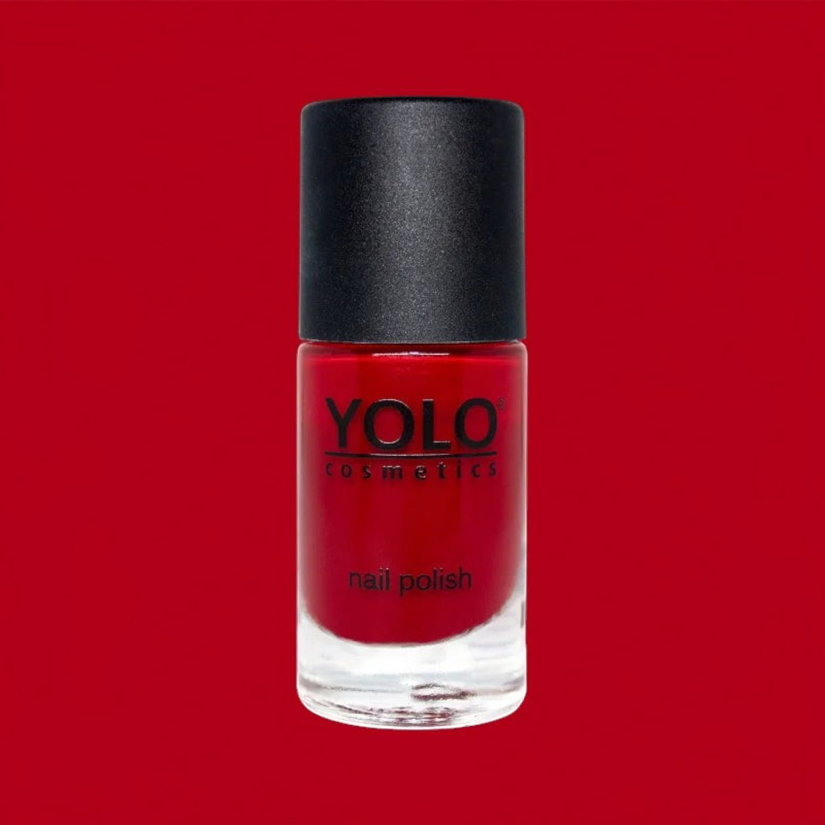 Said Salem YOLO Red nail polish in a sleek glass bottle with a black cap against a vibrant red background